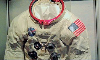 Neil Armstrong's Apollo 11 space suit is displayed in a glass case.