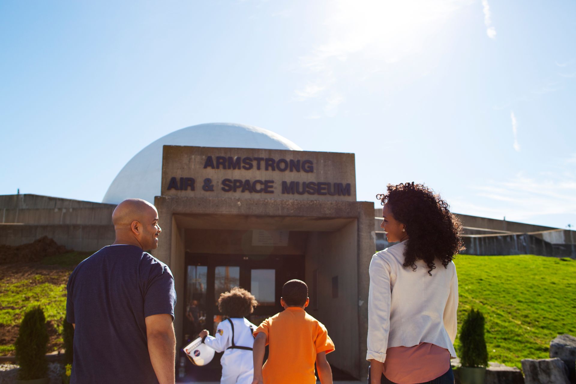 A family standing in front of the Armstrong Air & Space Museum.