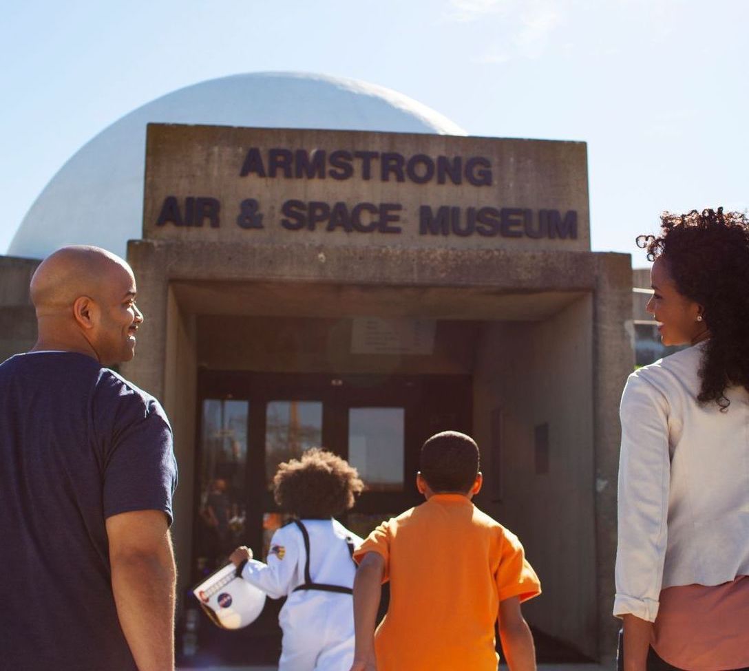 A group of people standing in front of the armstrong air & space museum