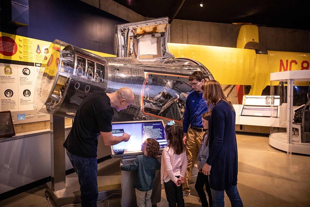 A family is looking at a display in a museum.