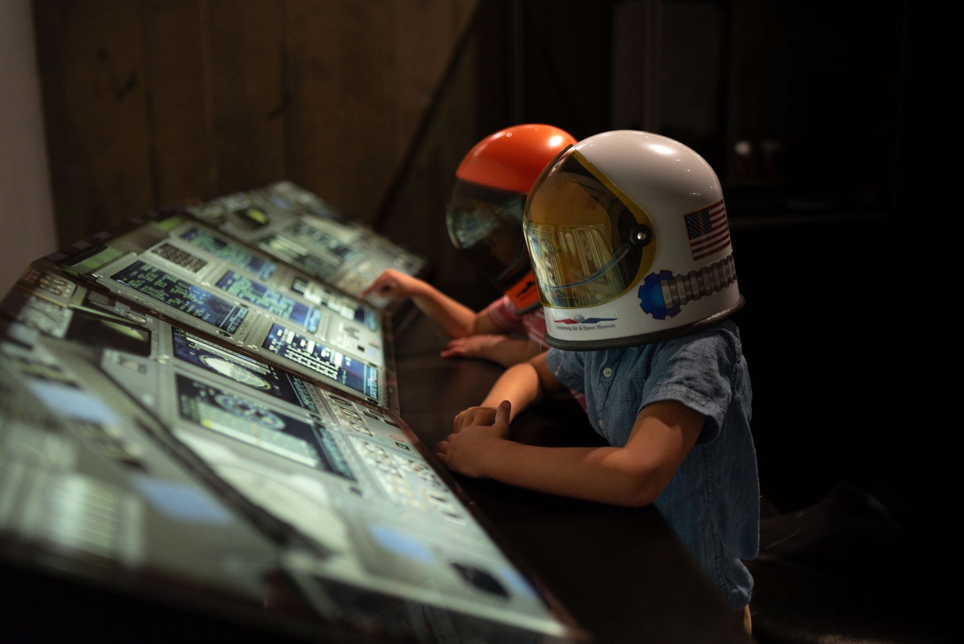 Two young astronauts looking at a control panel