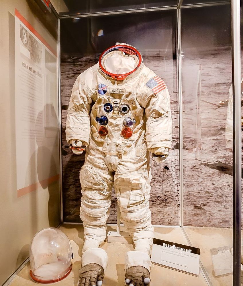 An astronaut 's suit is on display in a glass case.