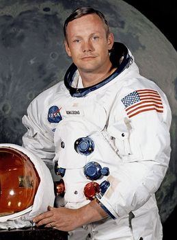 Neil Armstrong in a NASA space suit stands holding his helmet
