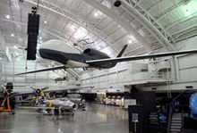 A fighter jet is hanging from the ceiling of a hangar in the Nation Museum of the United States Air Force.