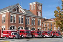 A row of fire trucks are parked in front of a the Wapakoneta Fire Station.