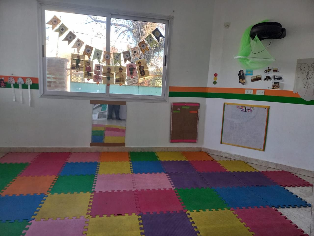 Una habitación con azulejos de colores en el suelo y una ventana.