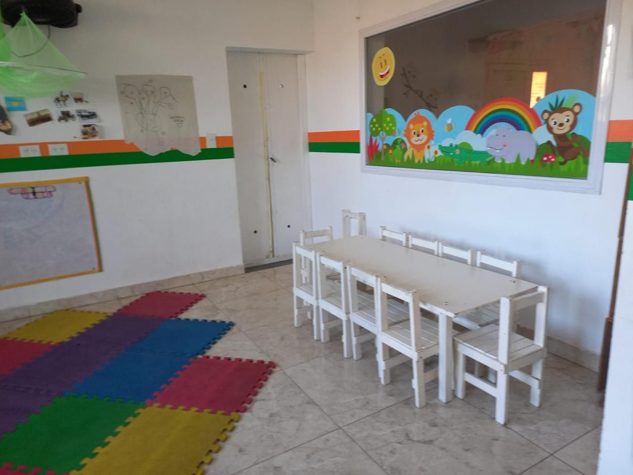 Una habitación con una mesa y sillas y un cuadro de animales en la pared.