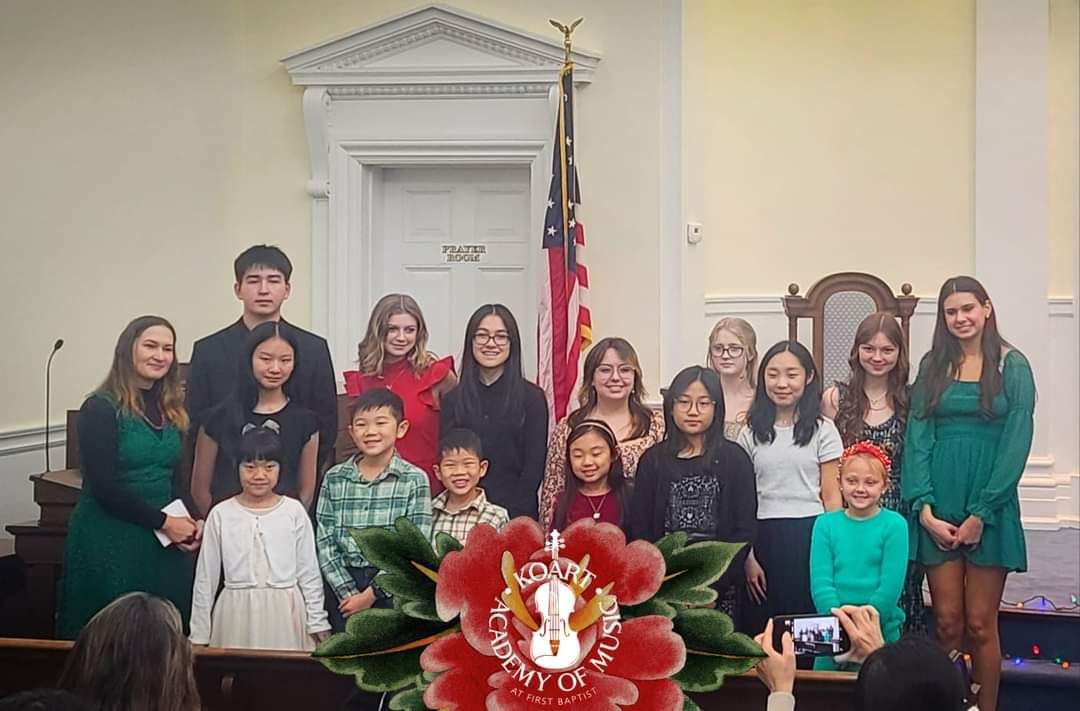 A group of young Koart Academy students are posing for a picture in a church.