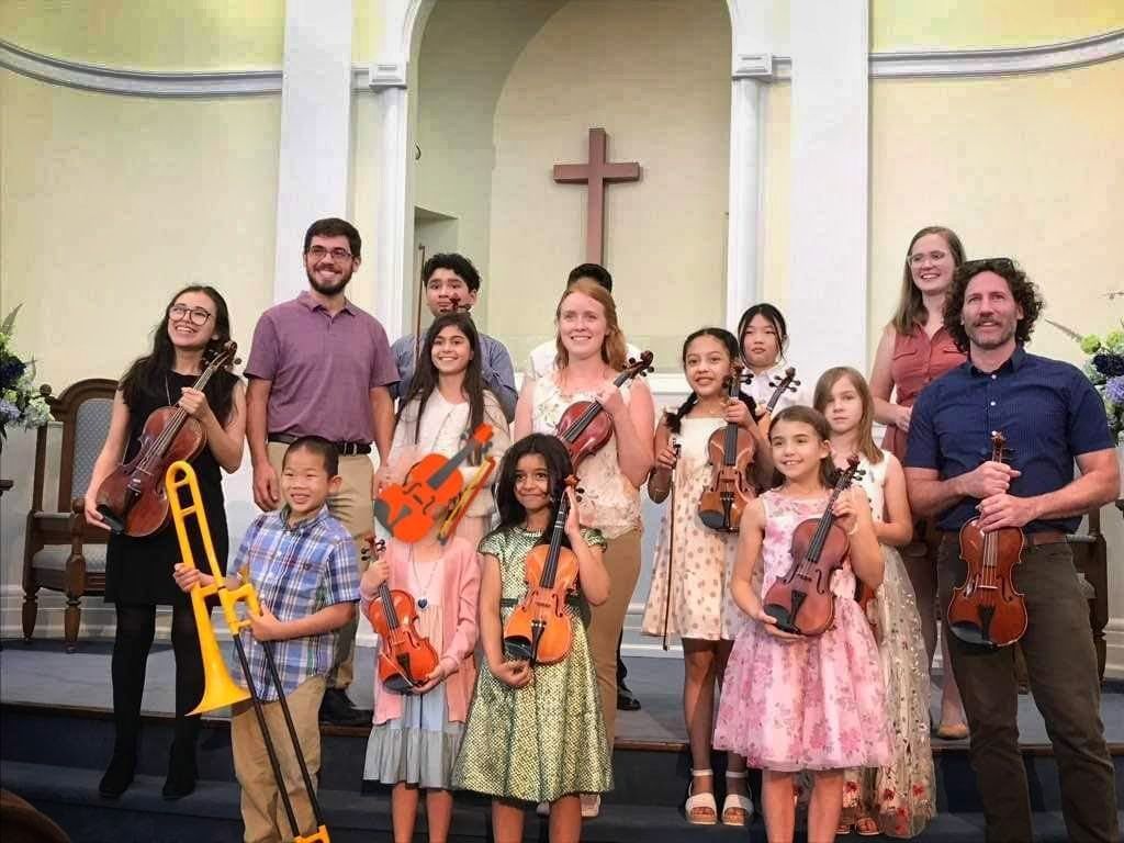 A group of children standing next to each other holding musical instruments.