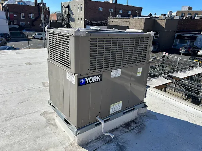 Gray York rooftop HVAC unit on a flat roof, outdoors on a sunny day.