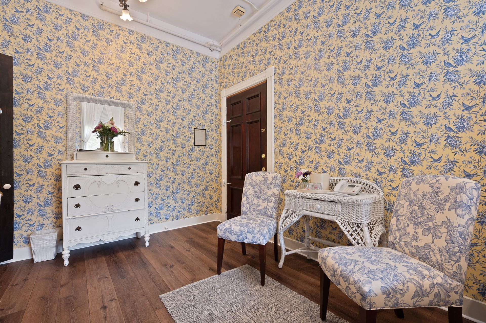 There are two chairs and a dresser in the room.