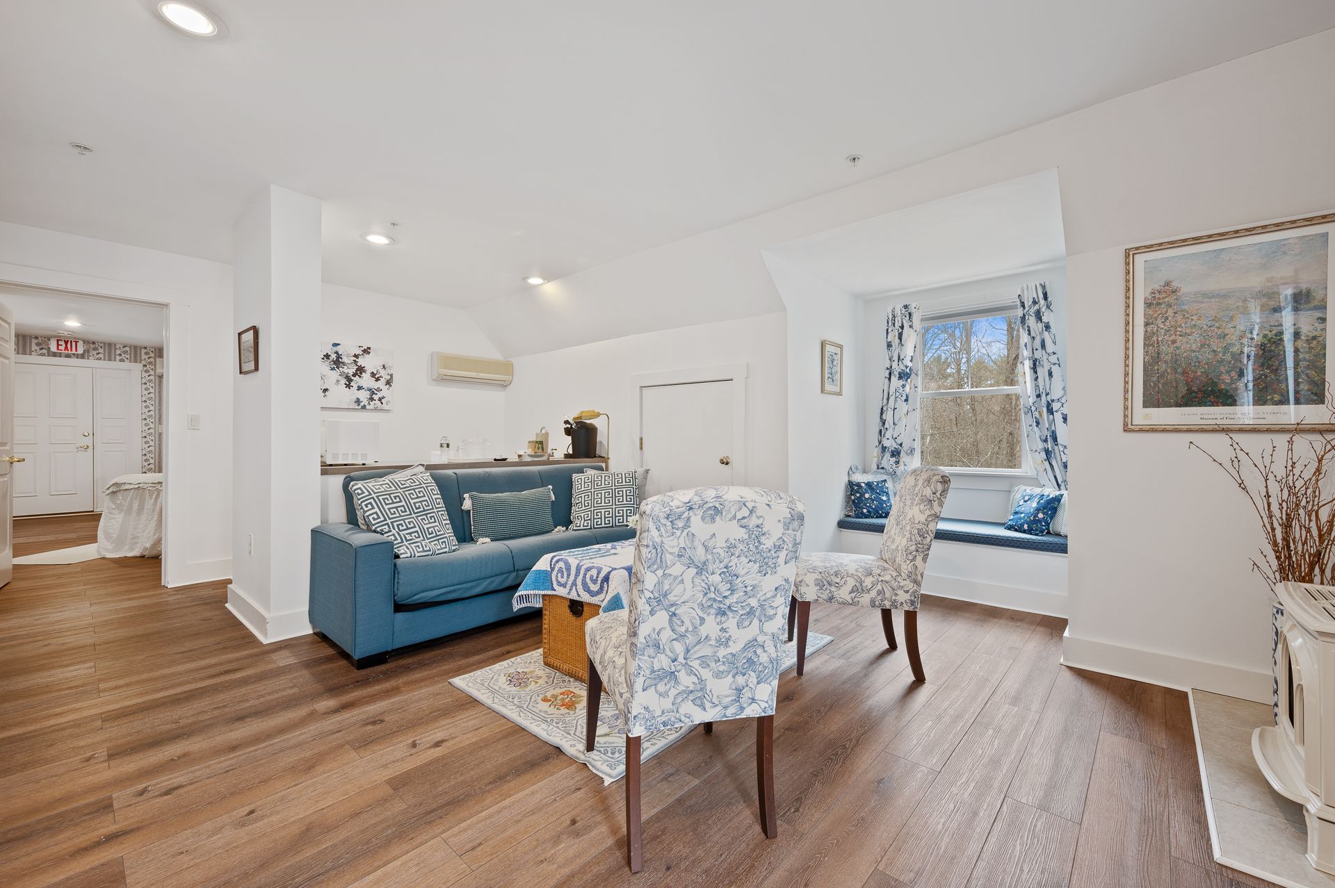 A living room with a blue couch and white chairs