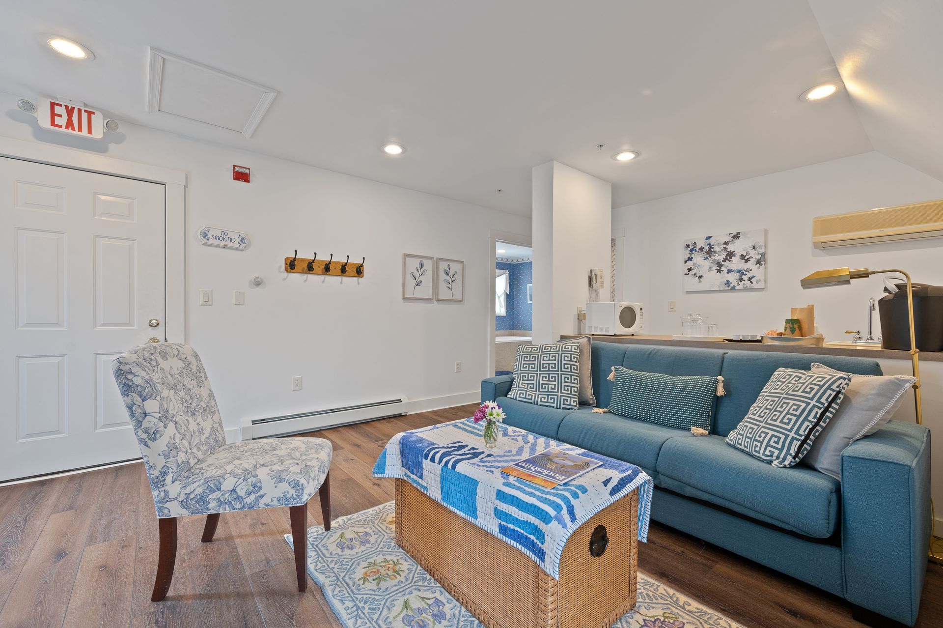 A living room with a blue couch , chairs and a coffee table.