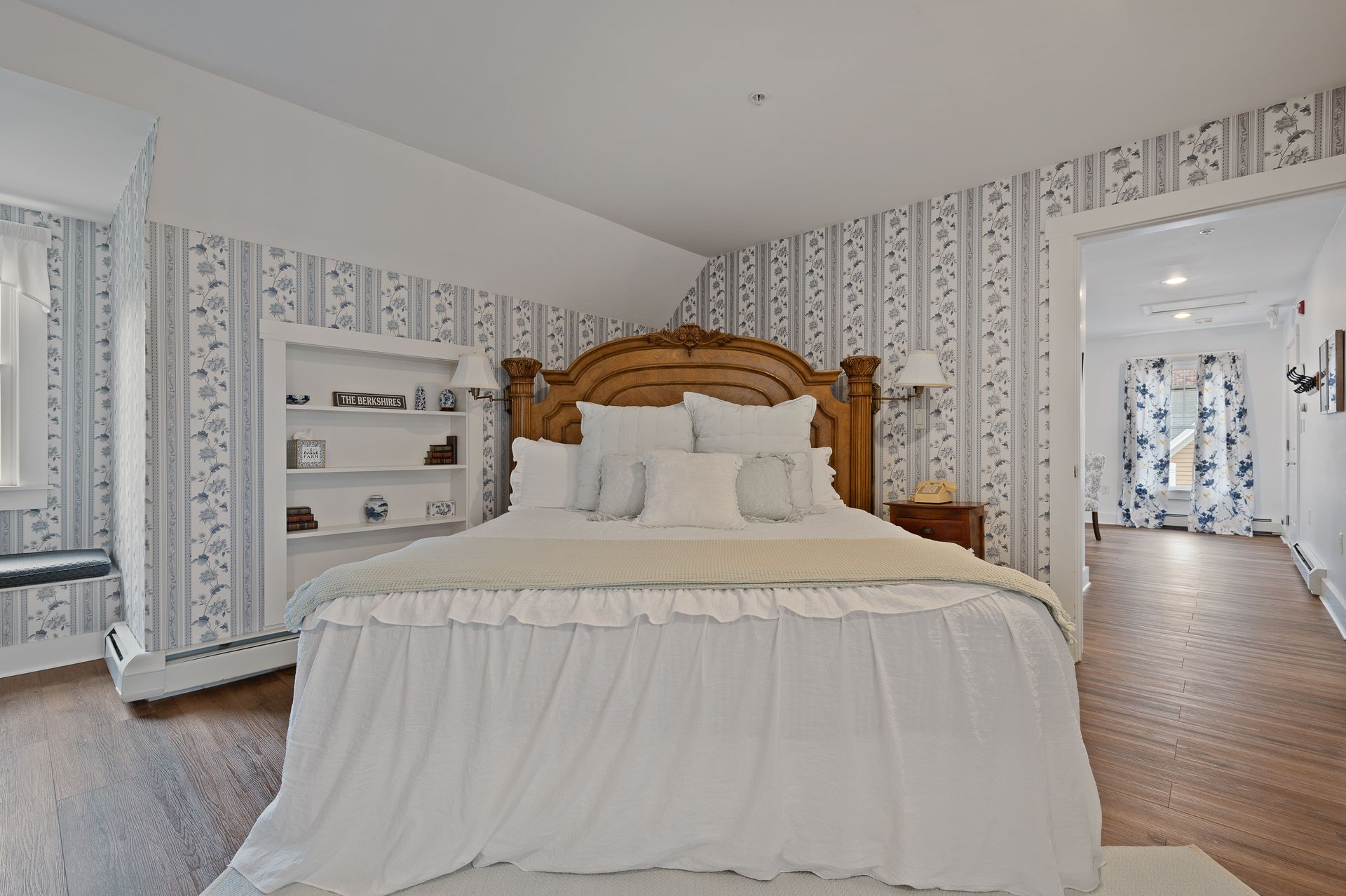A bedroom with a large bed and white sheets