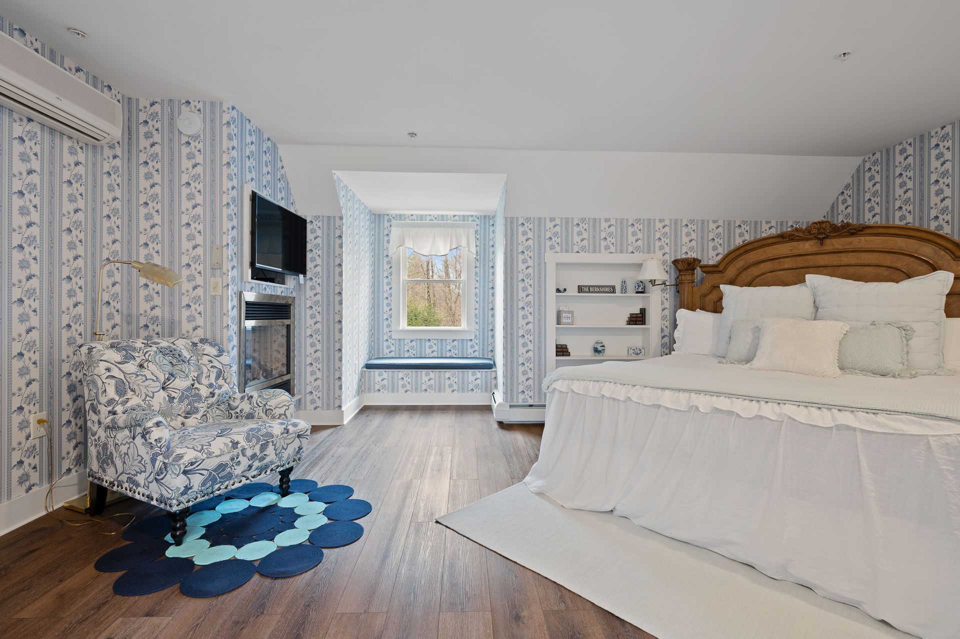 A bedroom with a large bed and a chair