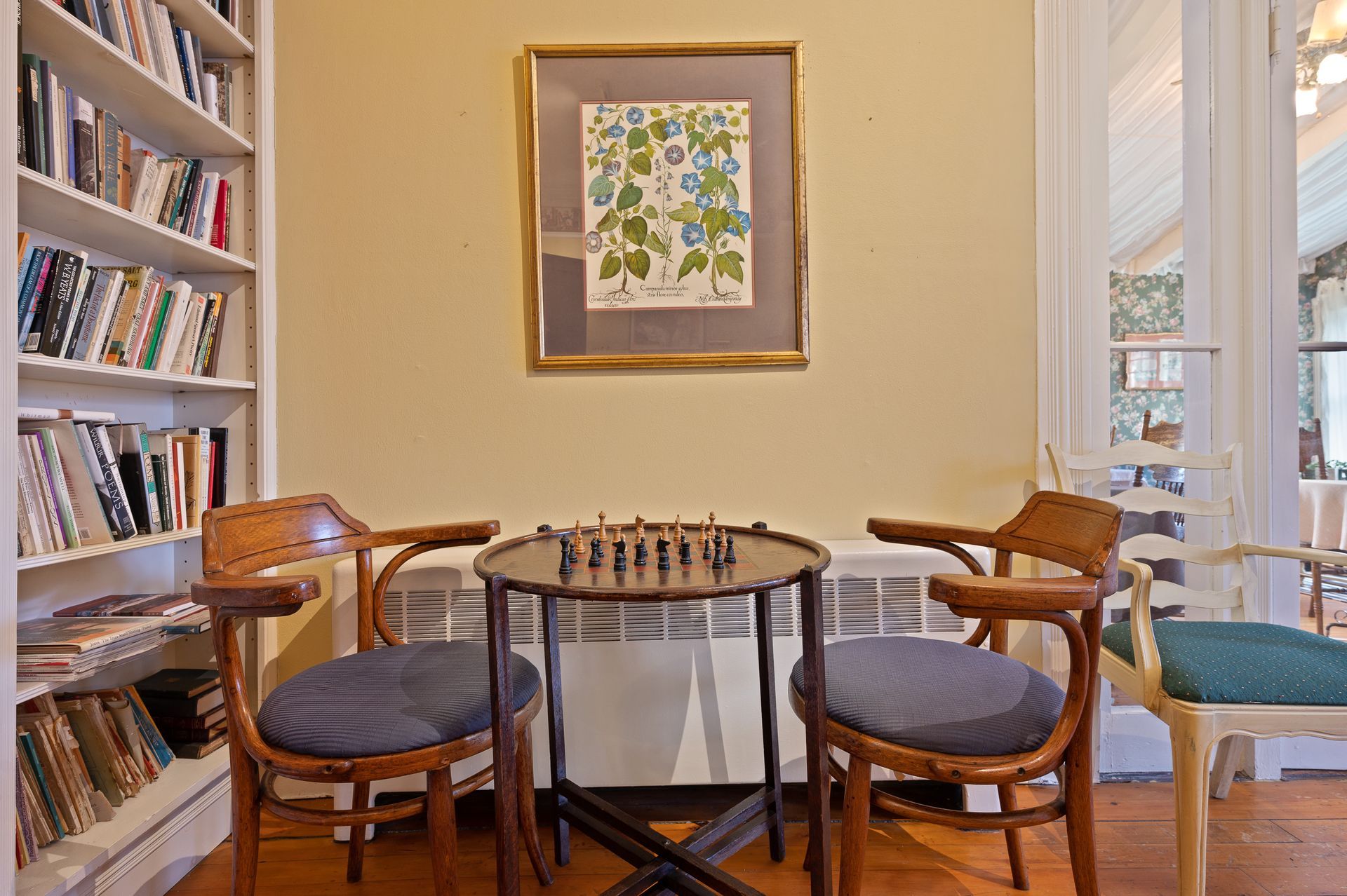 A room with a table and chairs and a picture on the wall