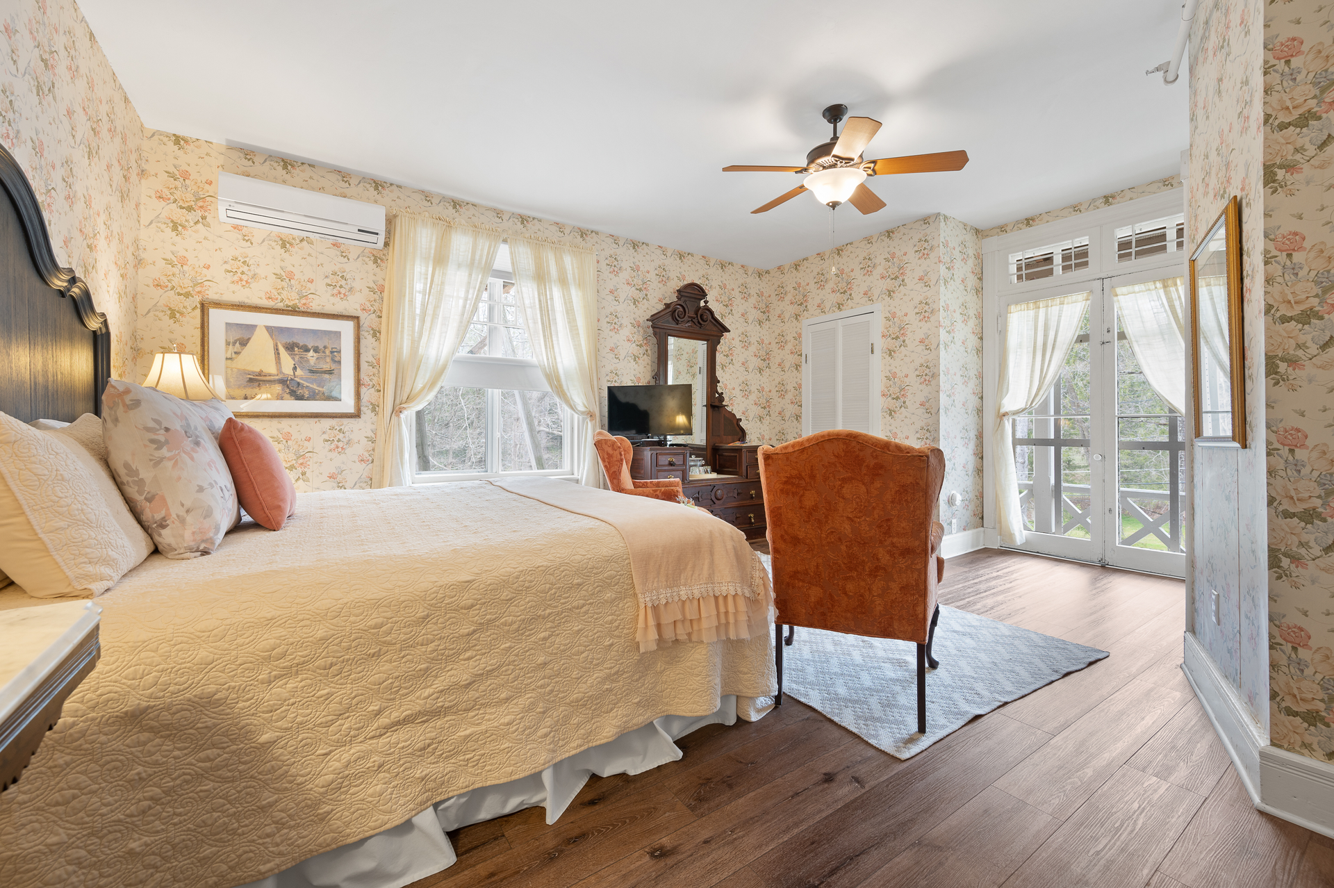 A bedroom with a king size bed and a ceiling fan.