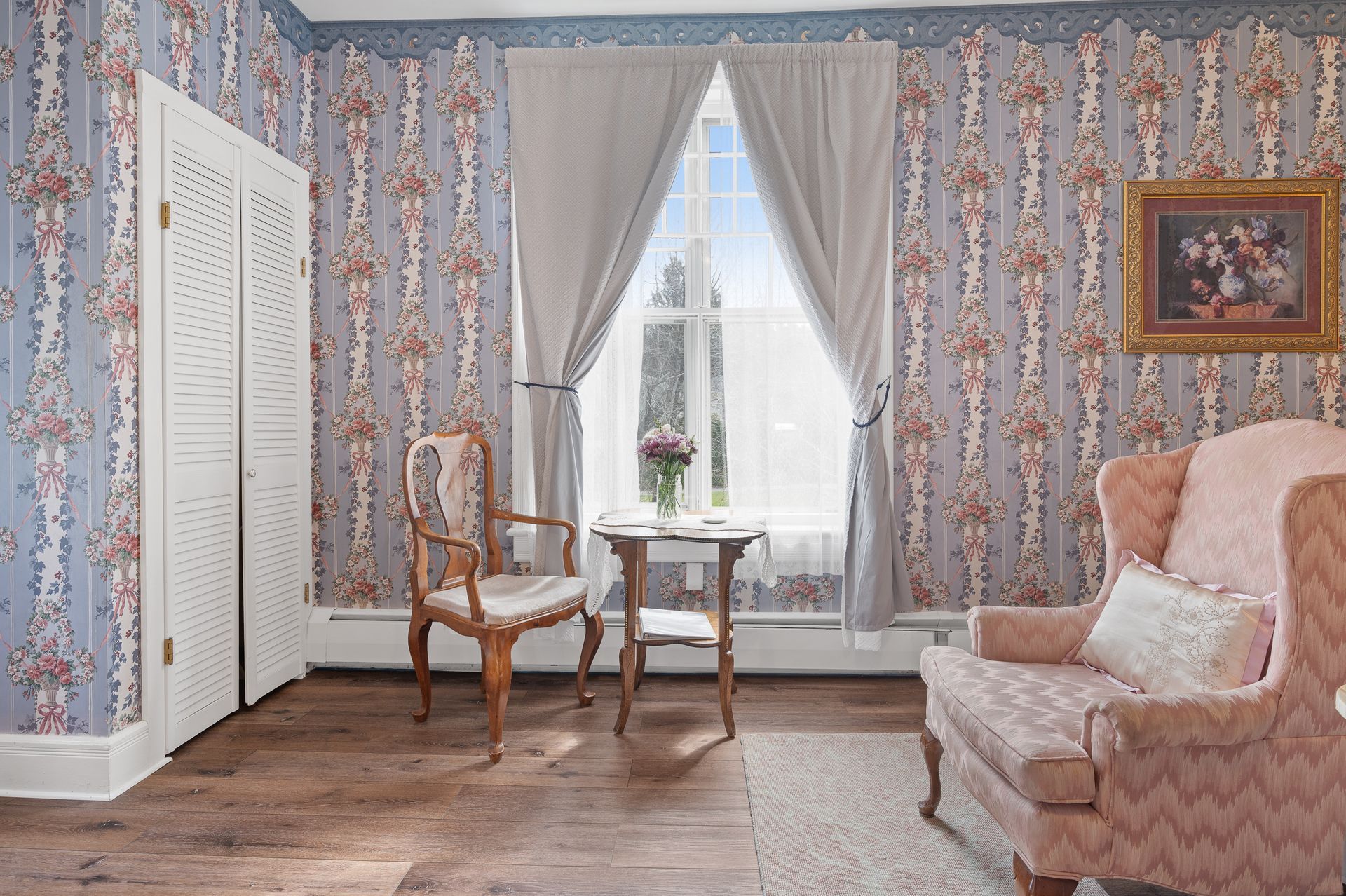 A living room with a couch , chair , table and window.