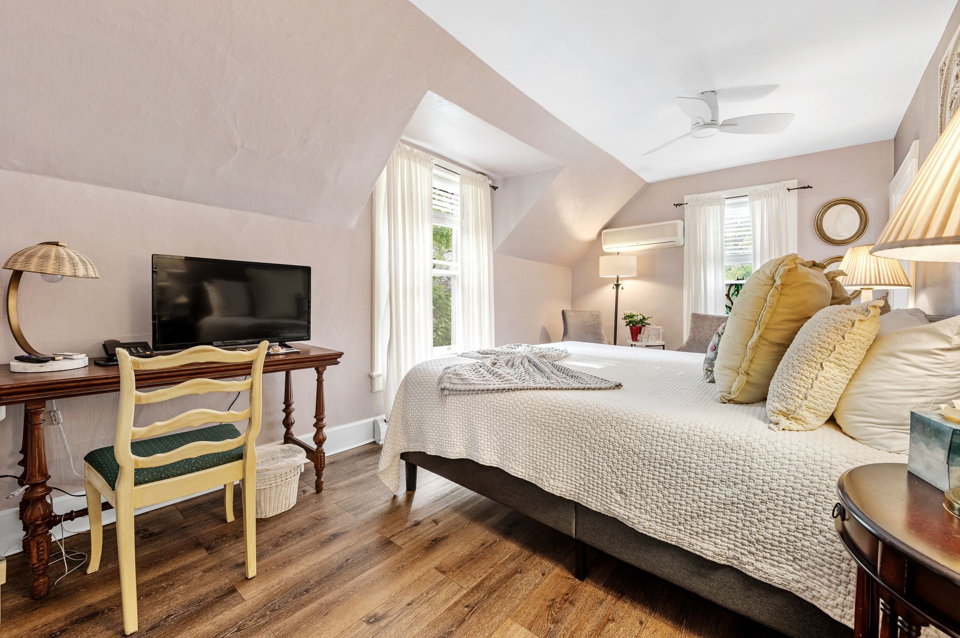 A bedroom with a large bed , desk , chair and television.