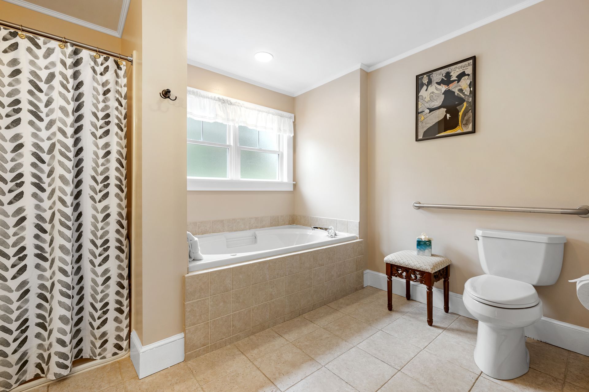 A bathroom with a tub , toilet , shower and window.