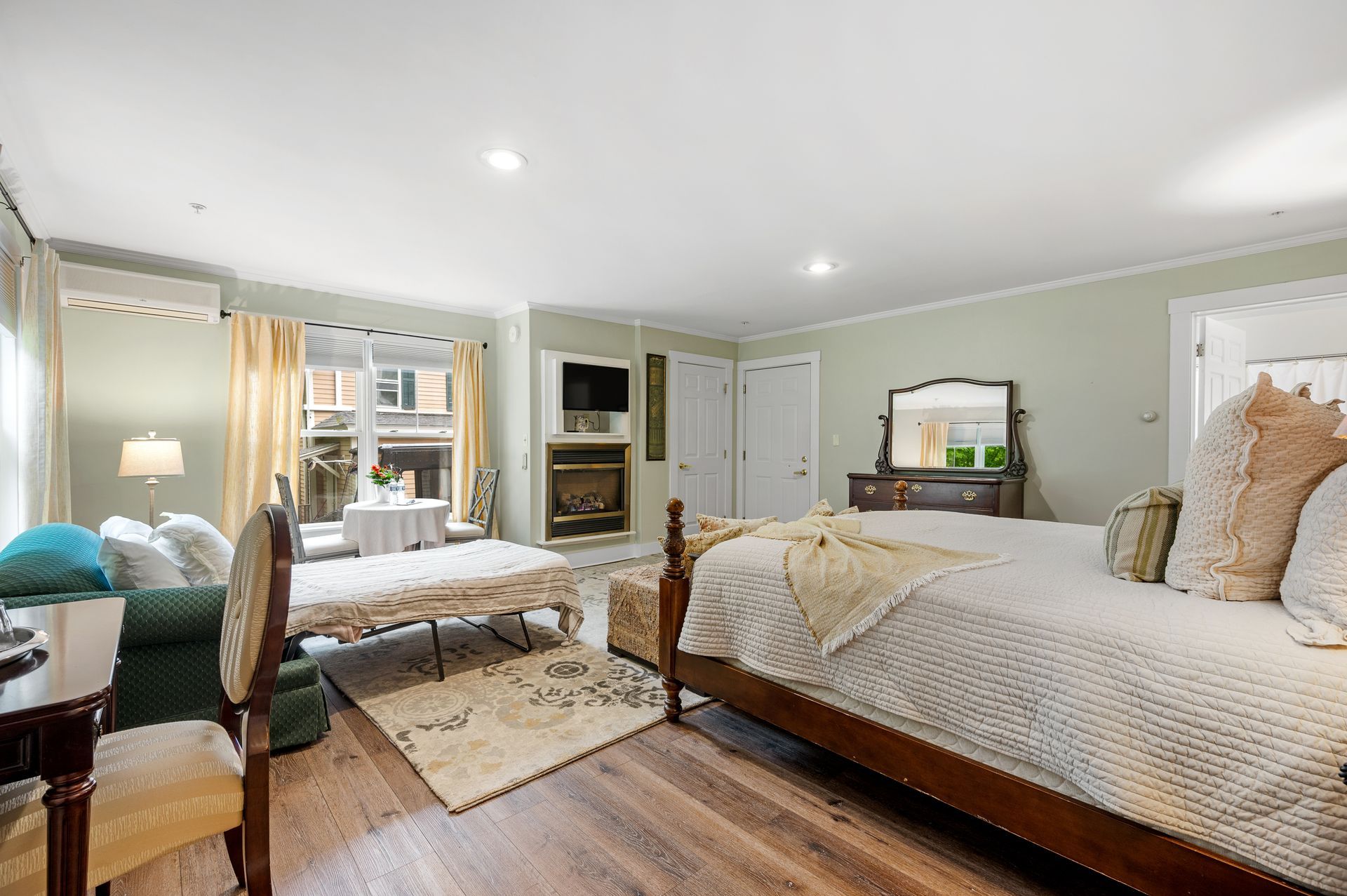 A bedroom with two beds , a couch , and a fireplace.