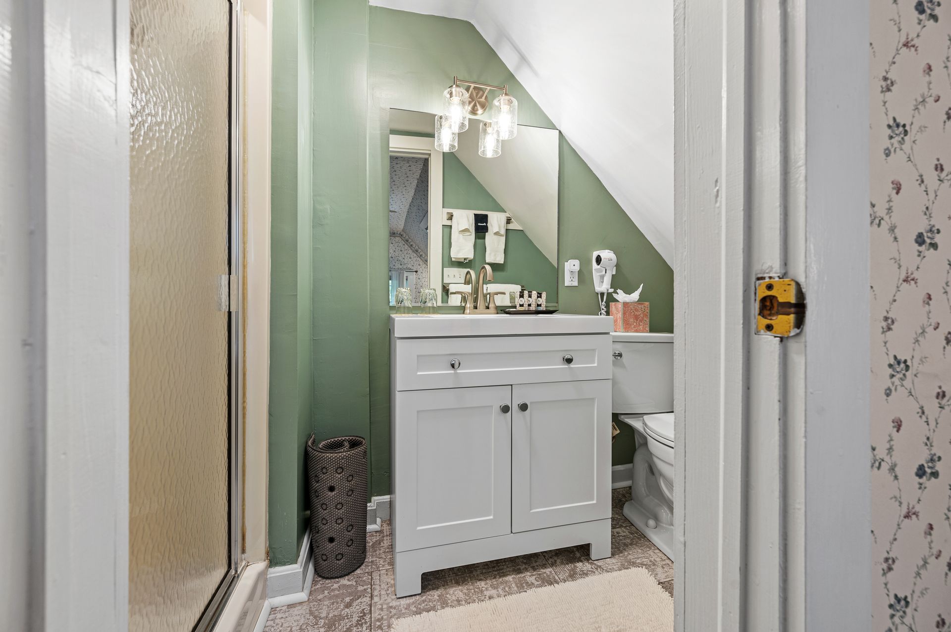 A bathroom with a sink , toilet and mirror.