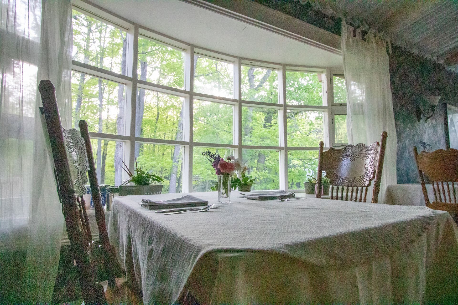 A table and chairs in a room with a large window.