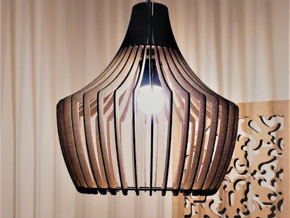 Pendant light fixture with wooden slats and black top, casting light. Set against a light brown background.
