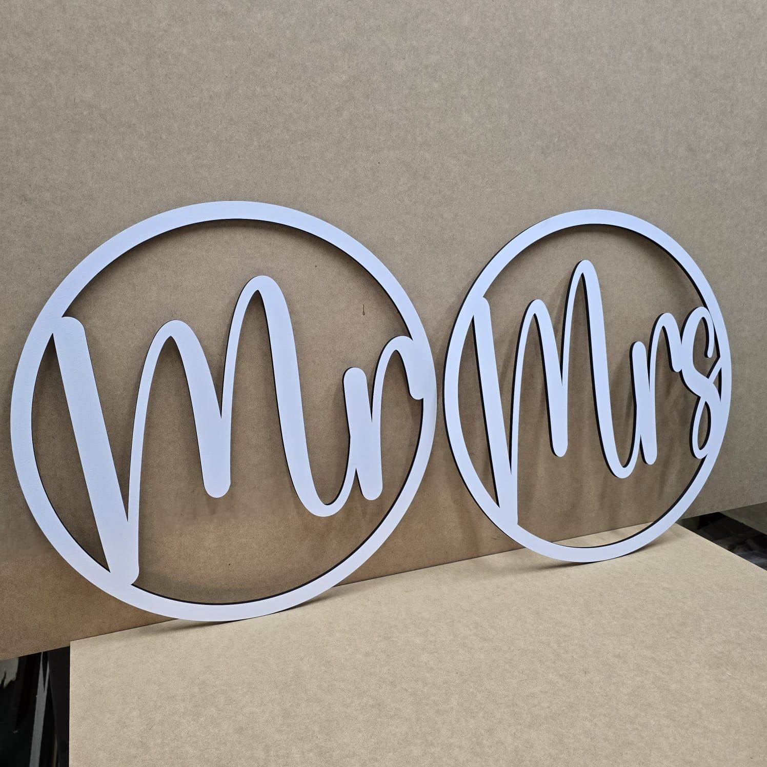 A blush pink loveseat with decorative pillows sits below a sign that reads