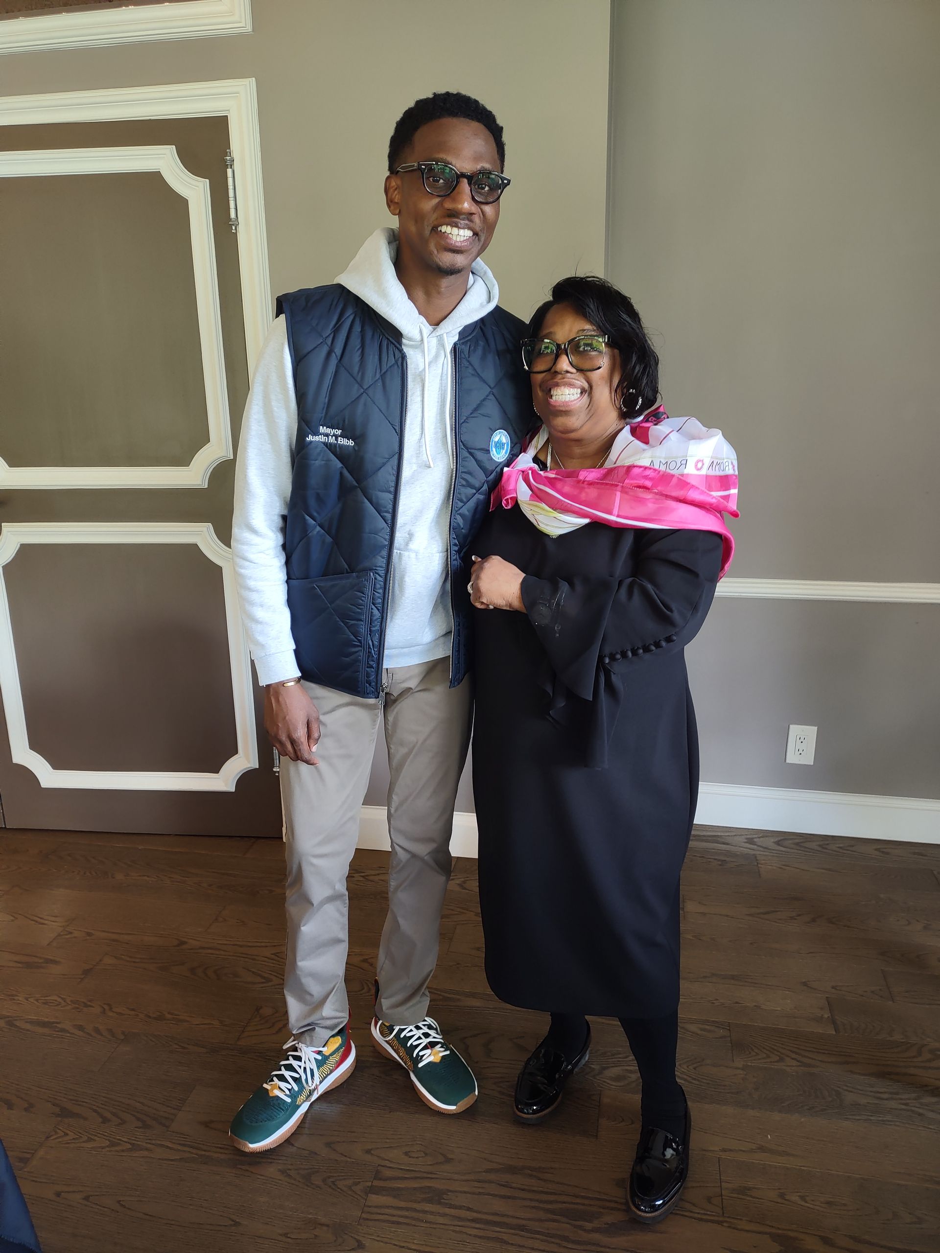 A man and a woman are posing for a picture in a room.