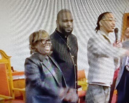 A group of people are standing next to each other in a room.