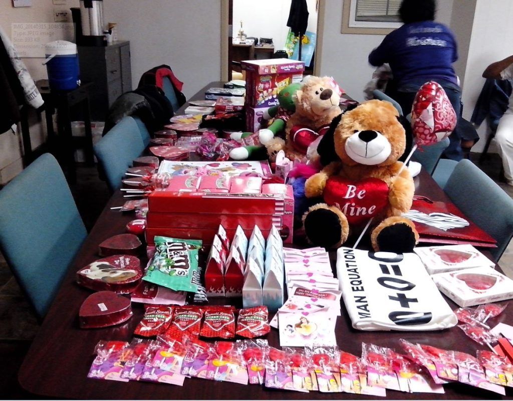 A teddy bear sitting on a table with a sign that says be mine
