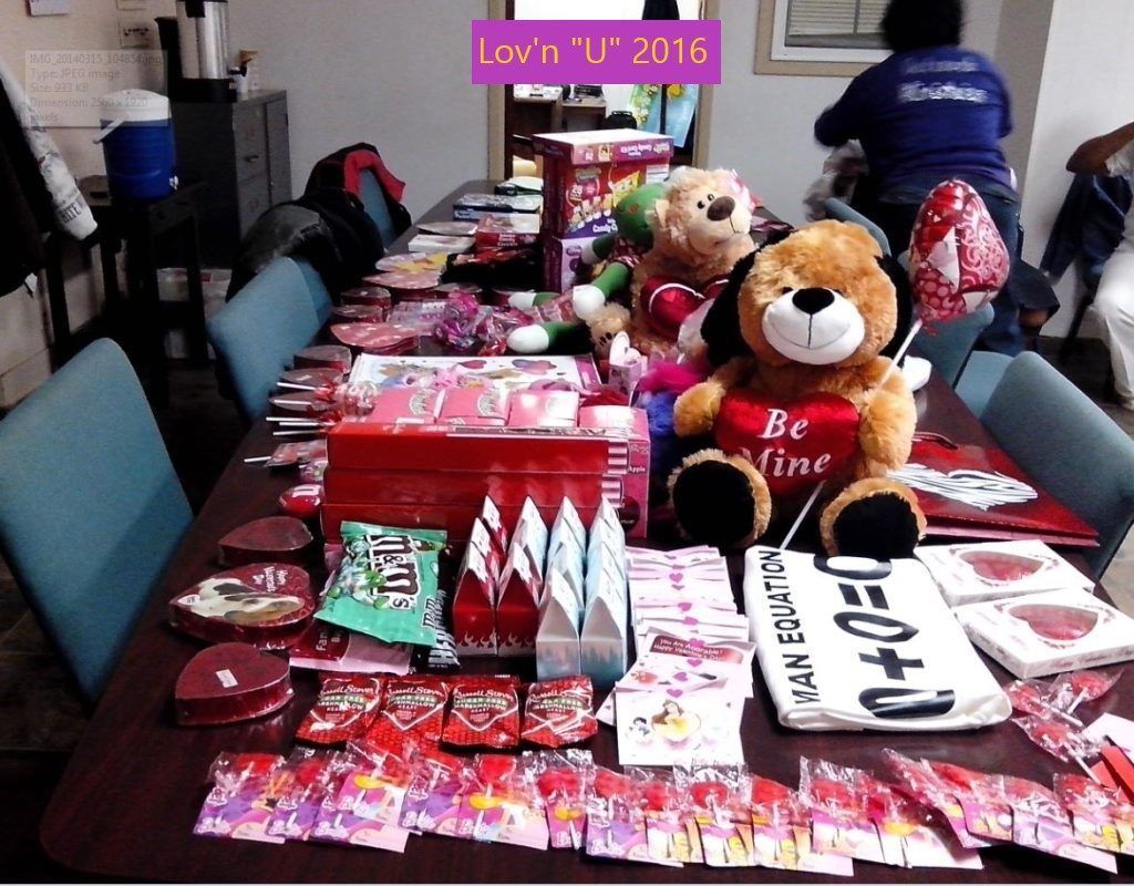 A table with stuffed animals and a sign that says i love u 2016