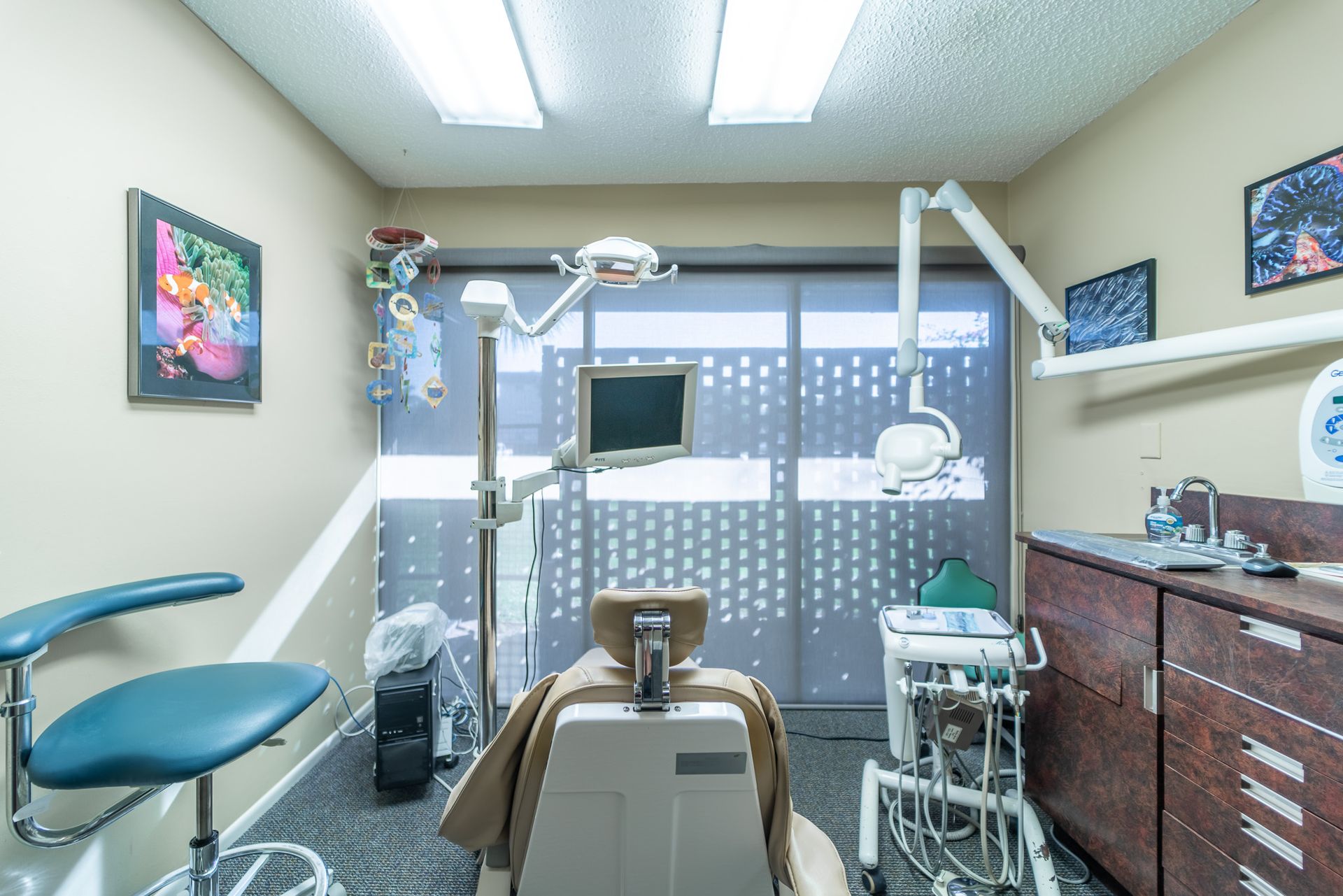 A dental office with a dental chair and a monitor.