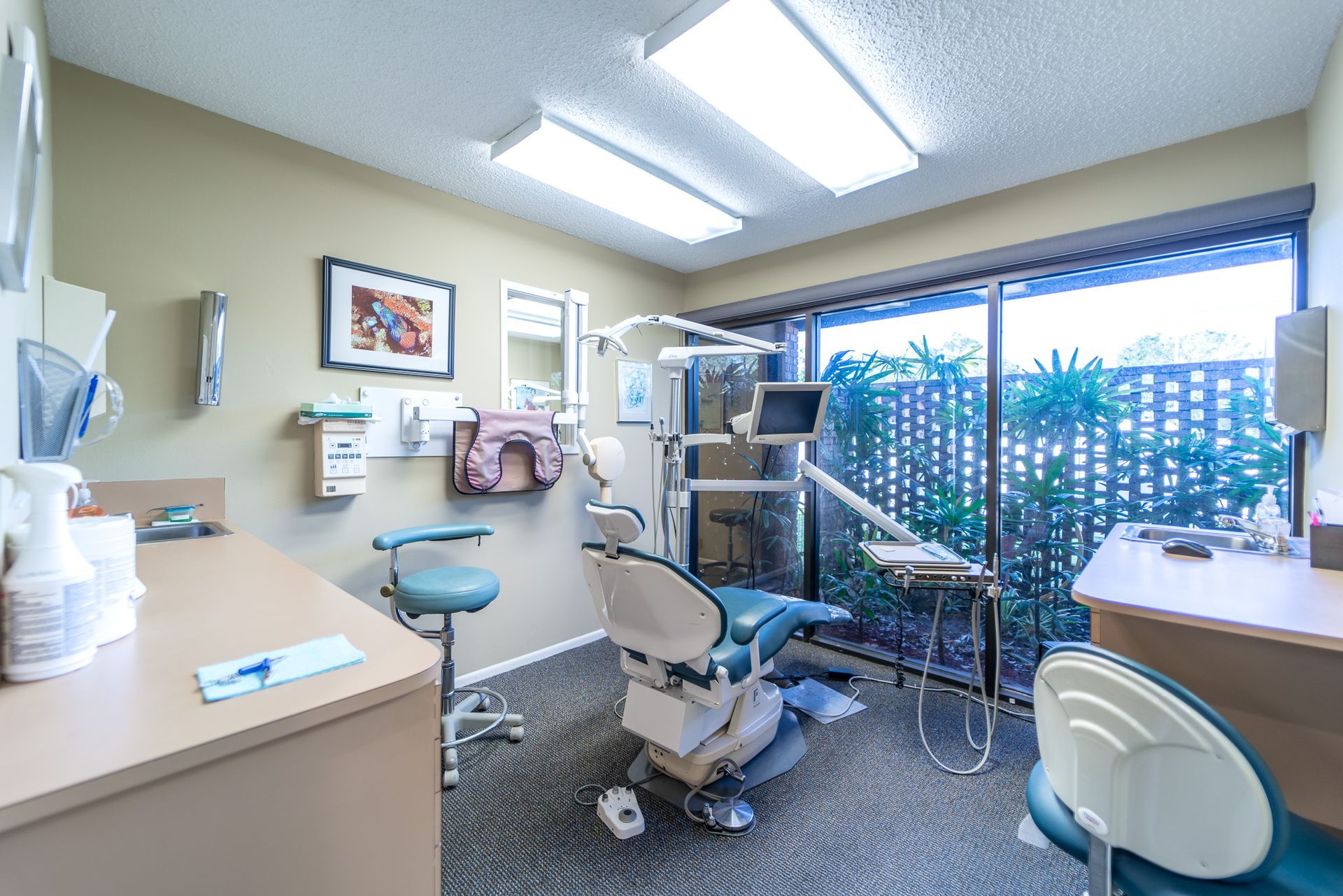 A dental office with a dental chair and a desk.