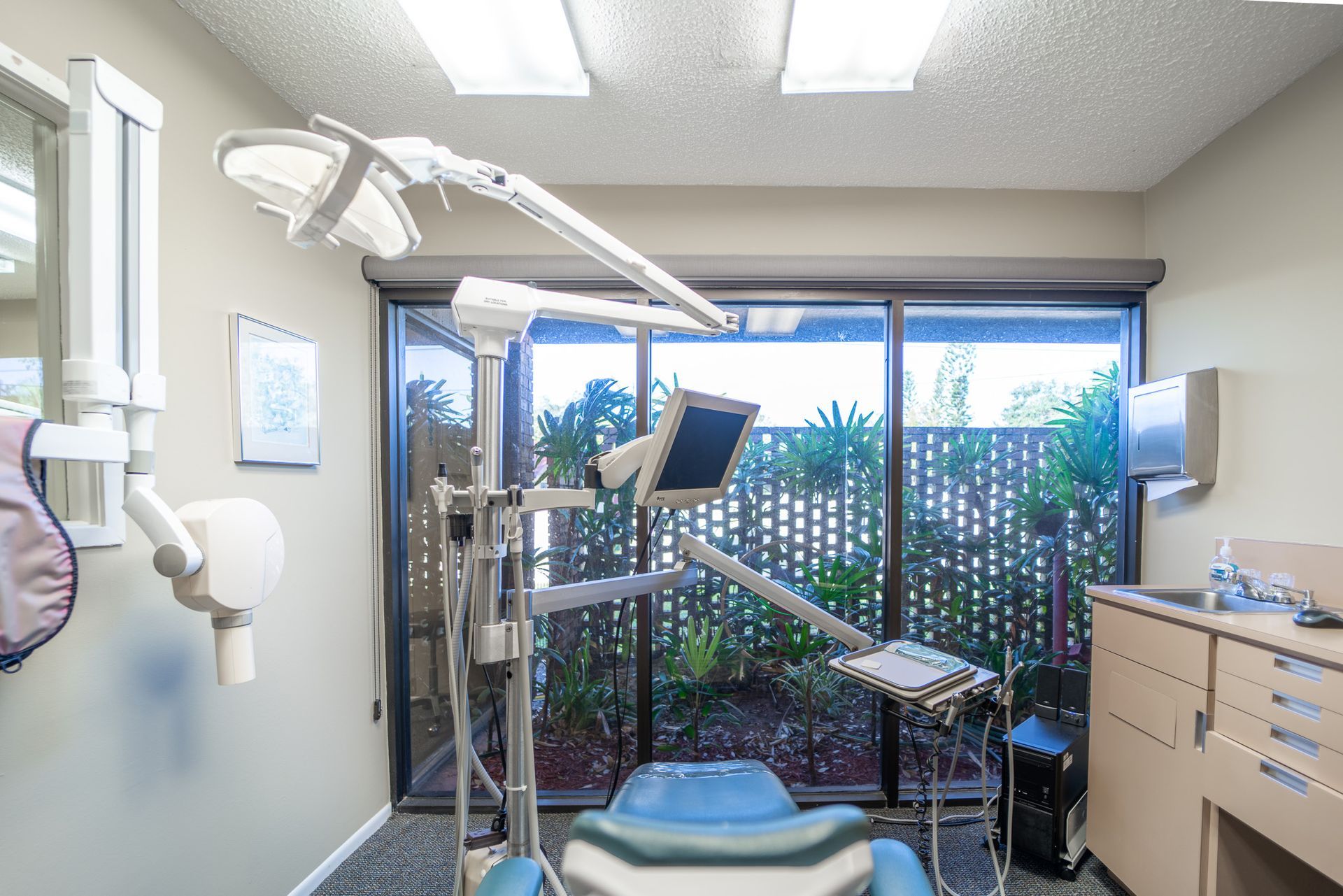 A dental office with a dental chair and a sink.
