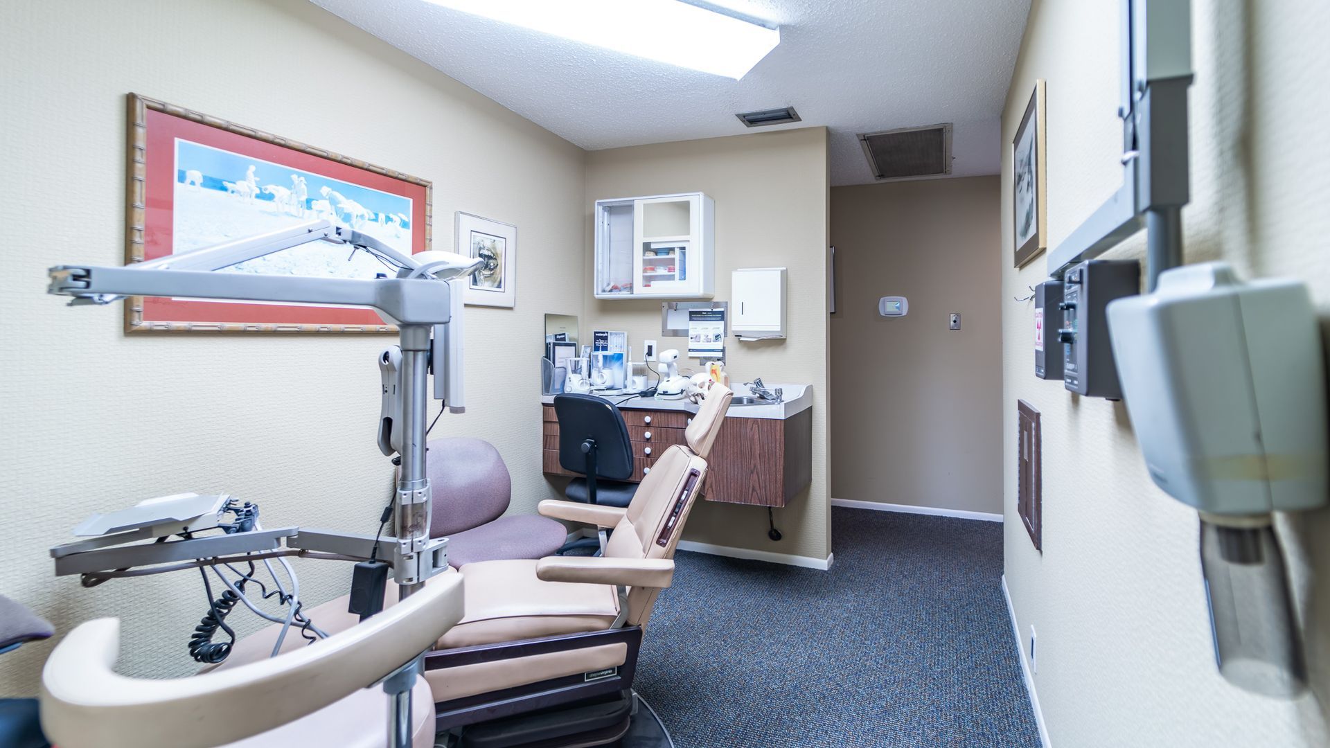 A dental office with a dental chair and a desk.