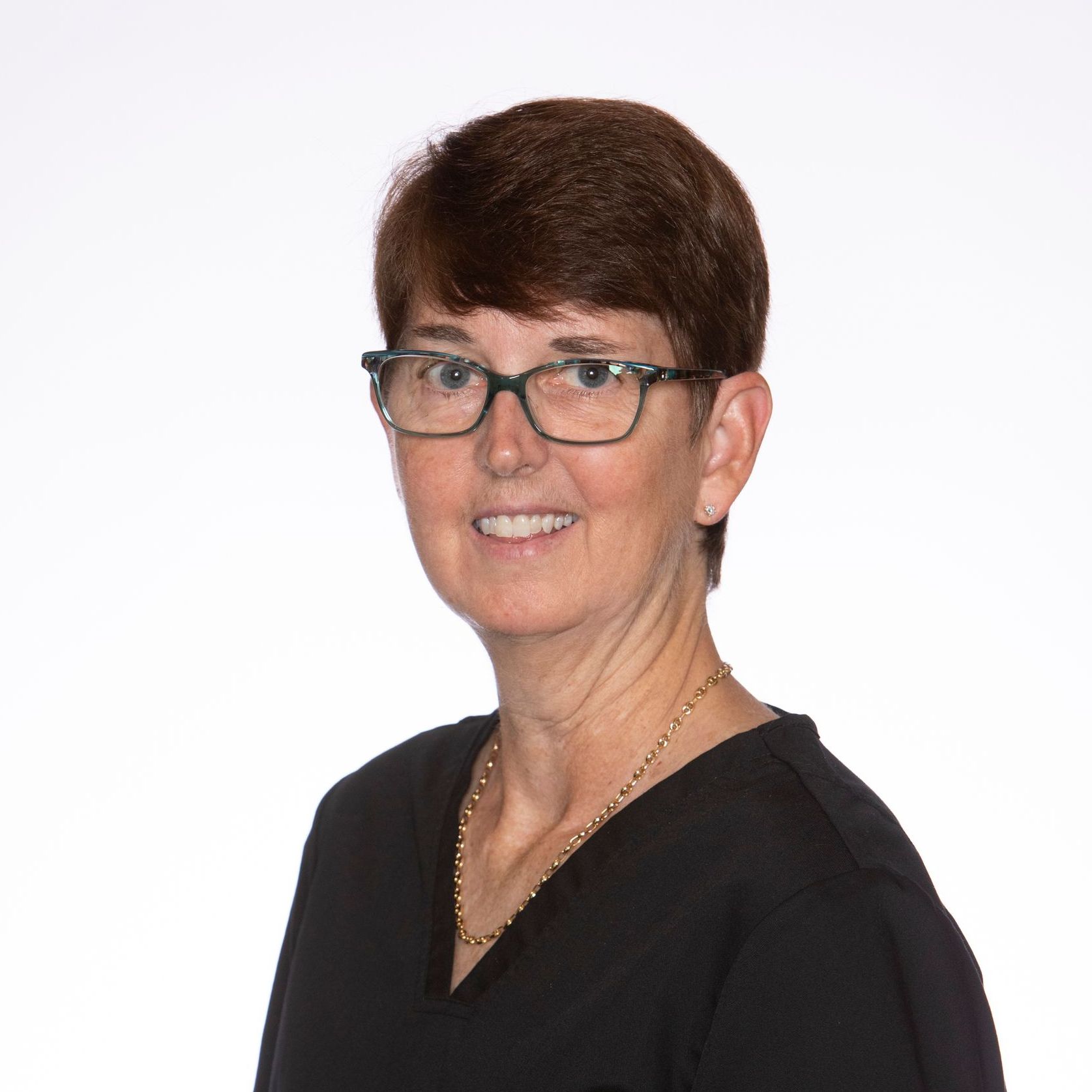 A woman wearing glasses and a black shirt is smiling for the camera.