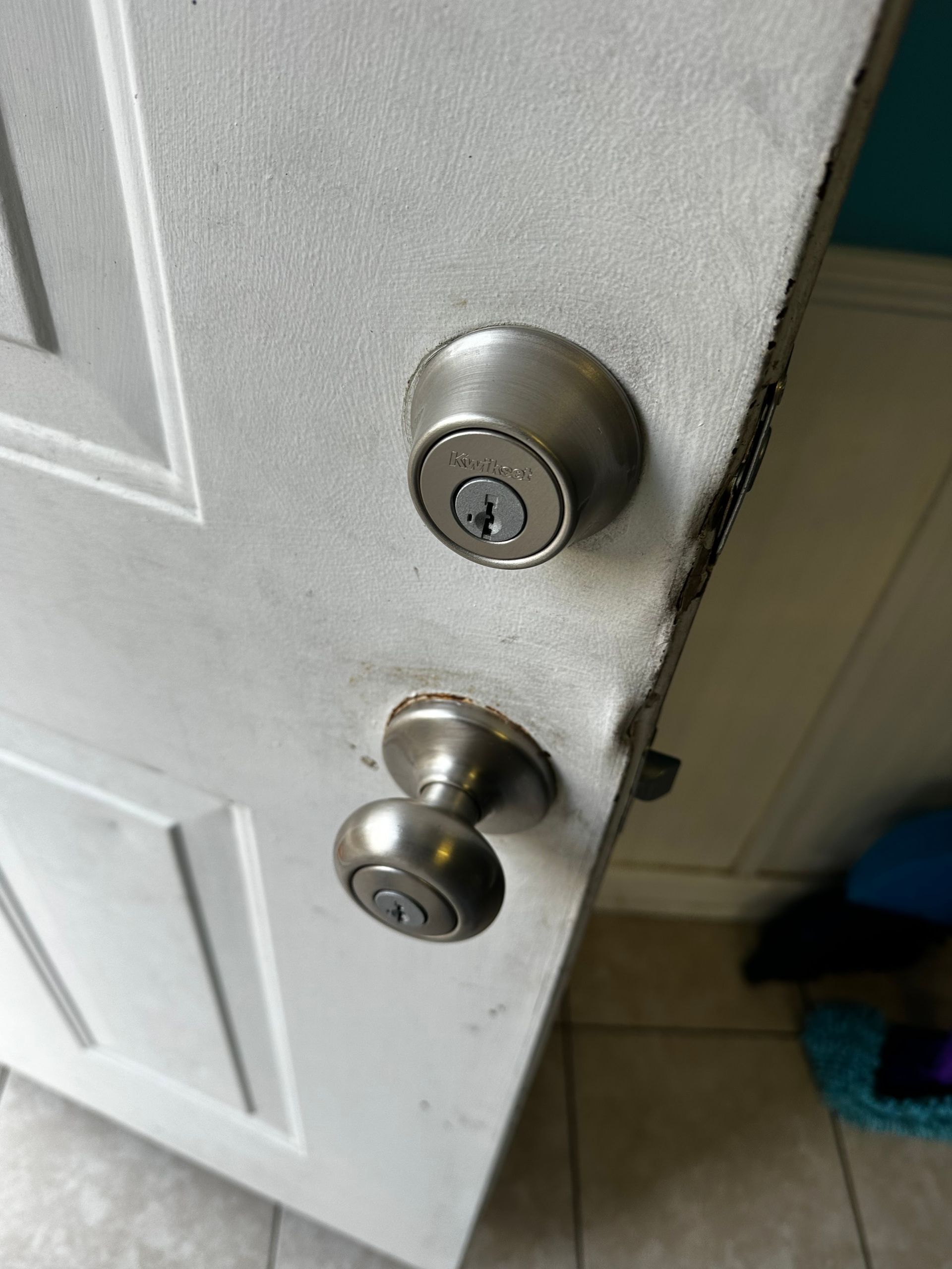 White door with silver doorknob and deadbolt lock.