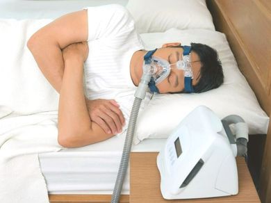 A man is sleeping with an oxygen mask on his face