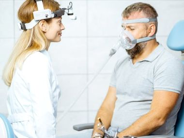 A man is sitting in a chair with an oxygen mask on his face.