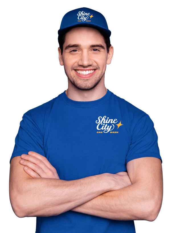 Man in blue Shine City uniform smiles with arms crossed.
