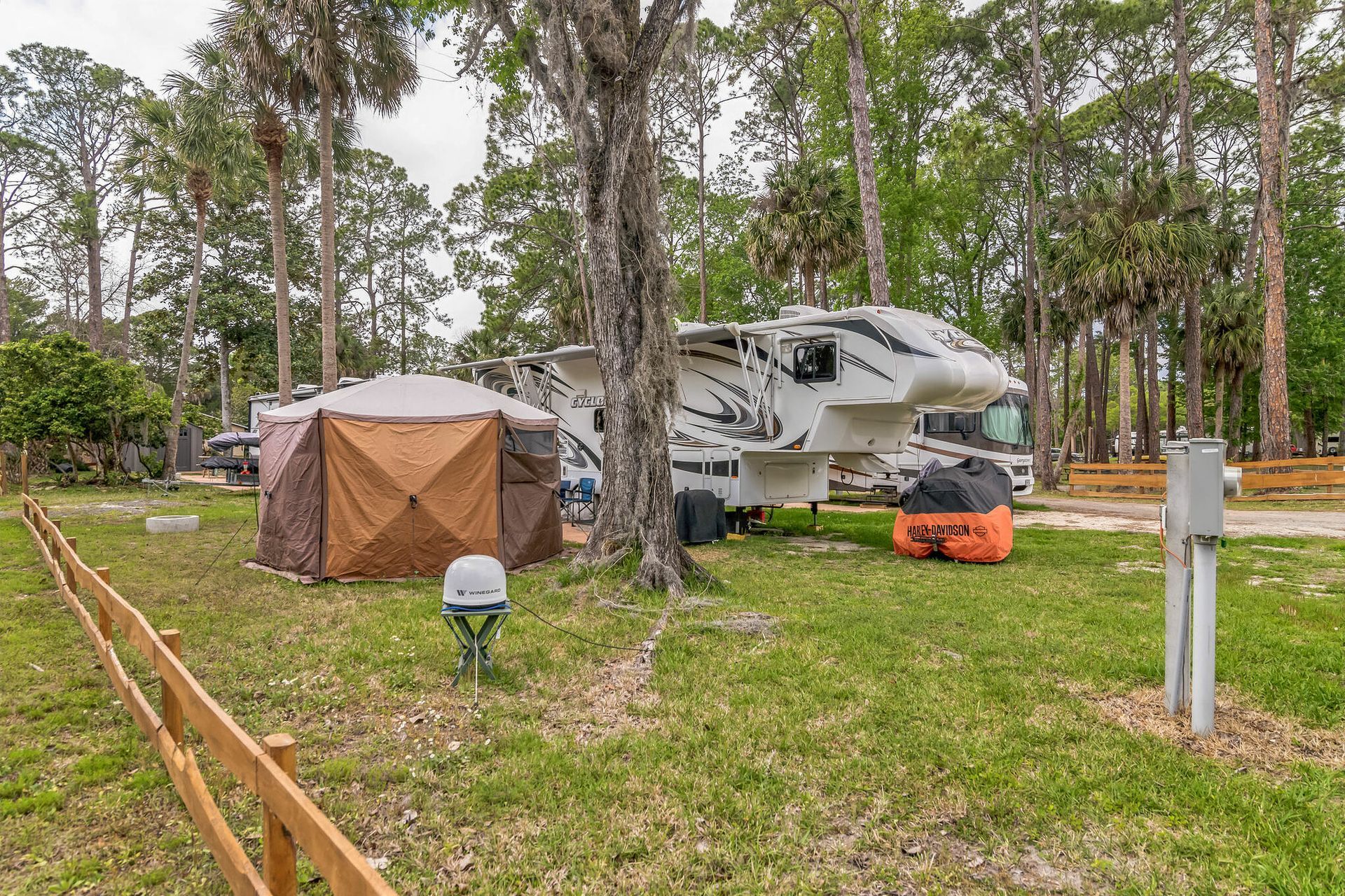 a rv parked in a grassy area next to a tent