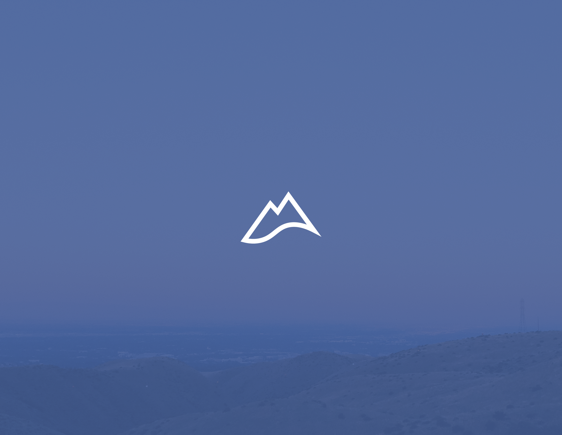A white mountain is against a blue sky.