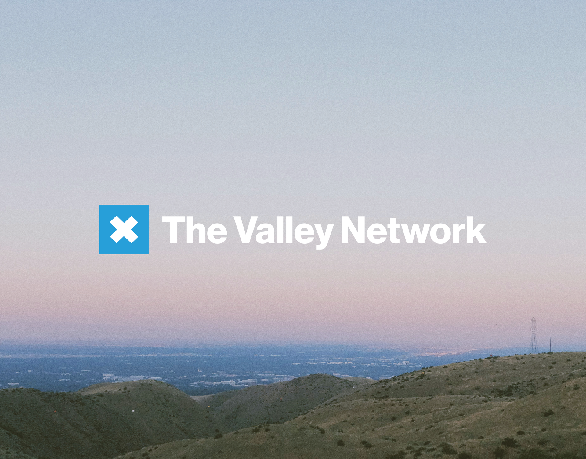 A logo for the valley network with a mountain in the background
