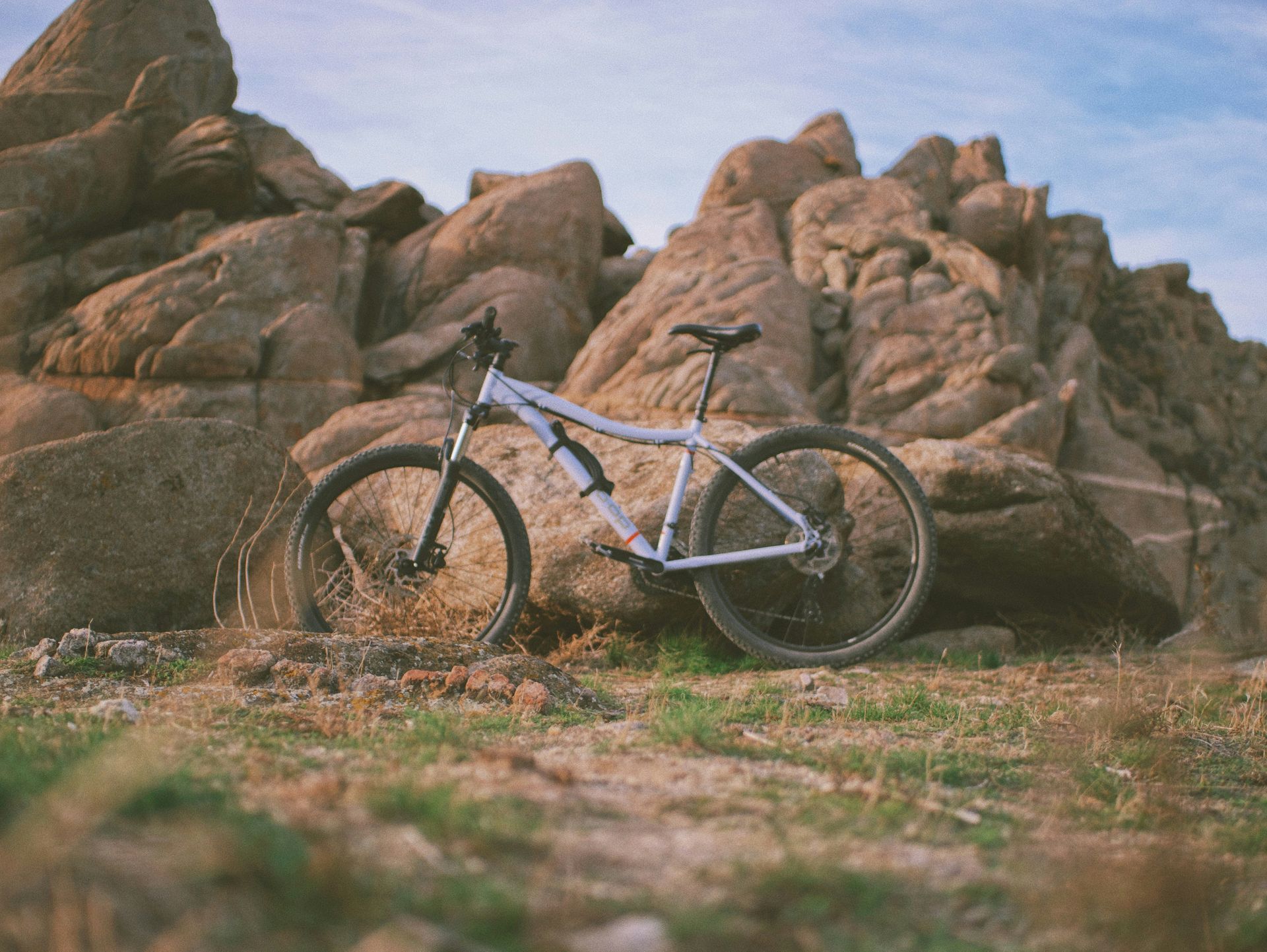 A bicycle is parked in front of a rocky mountain.