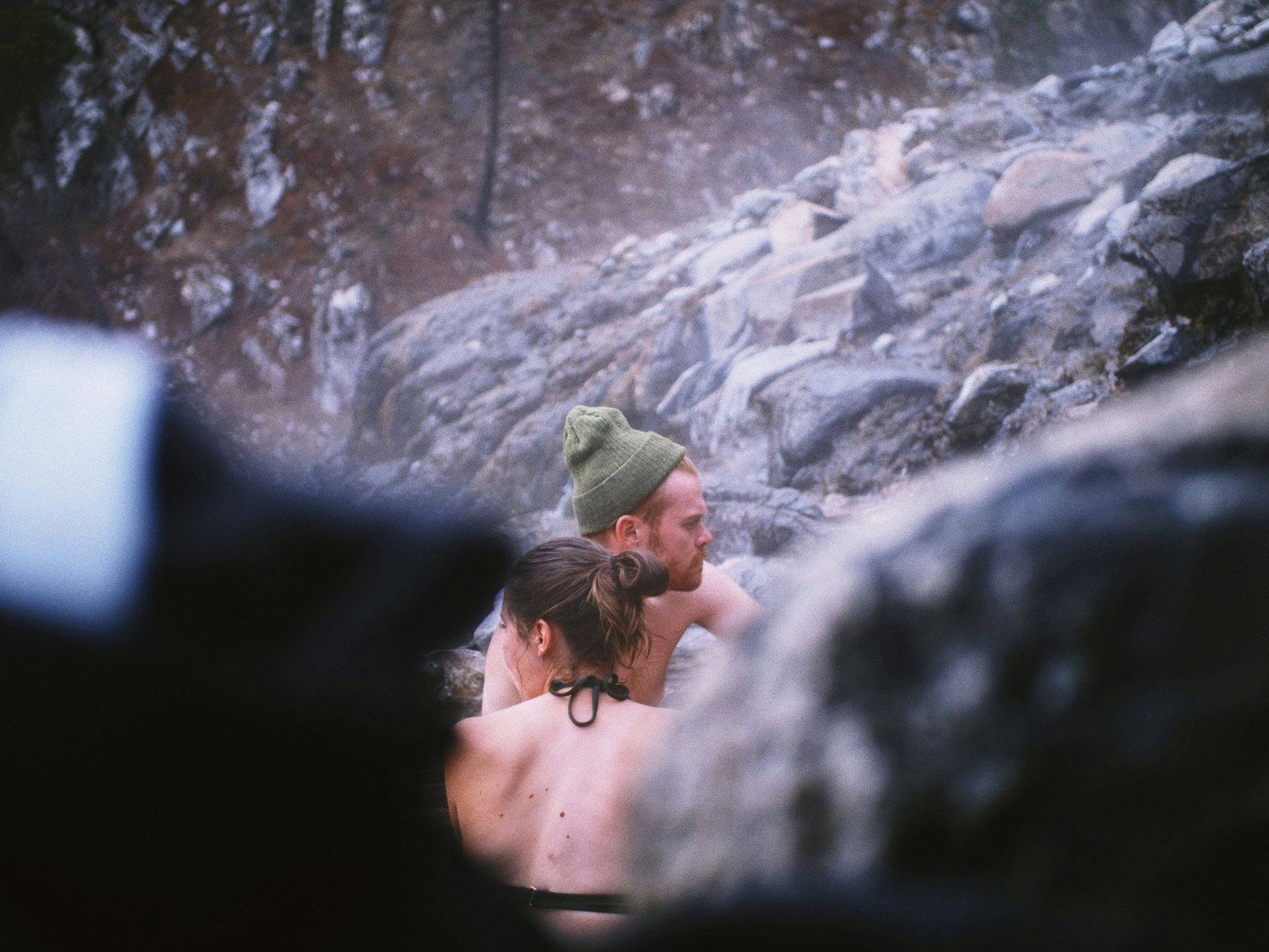 A man and a woman are taking a bath in a hot spring.