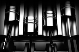 Una fotografía en blanco y negro de una fila de cilindros en el motor de un automóvil.