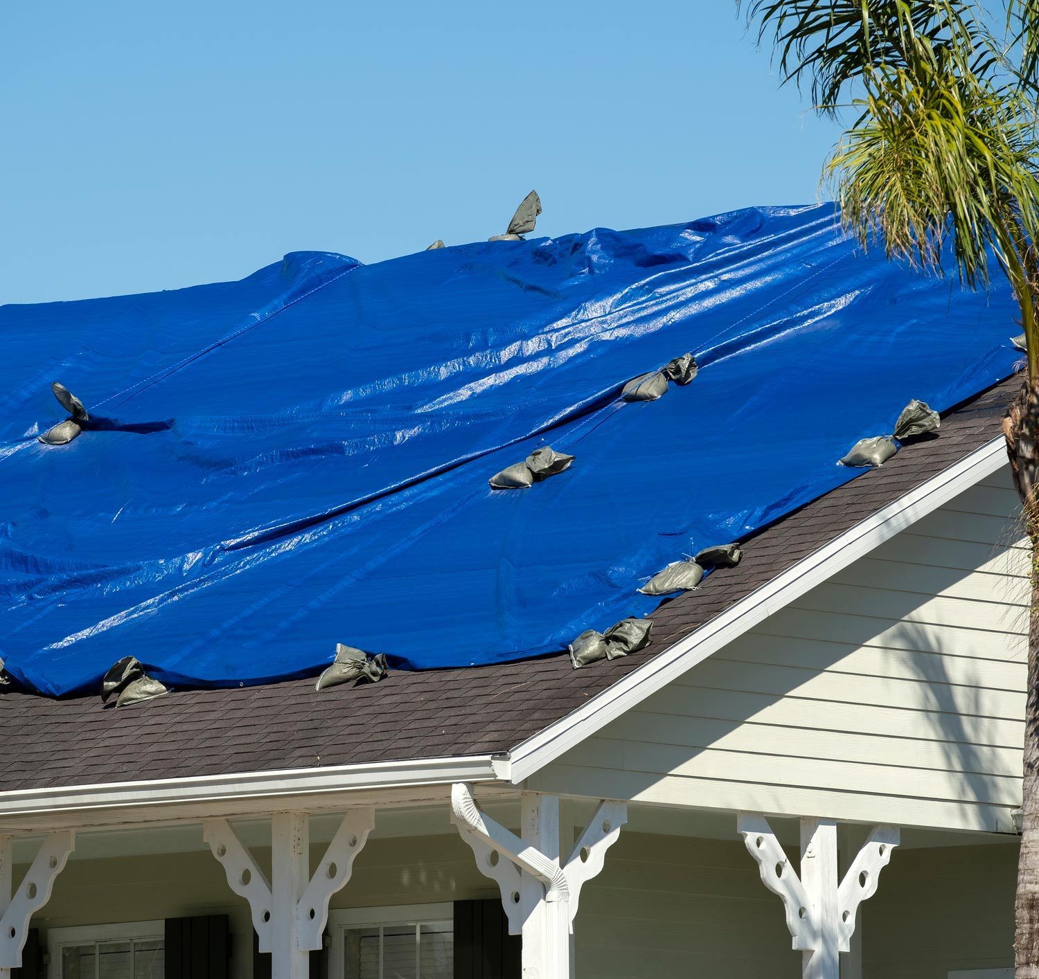 A Blue Tarp is Covering the Roof