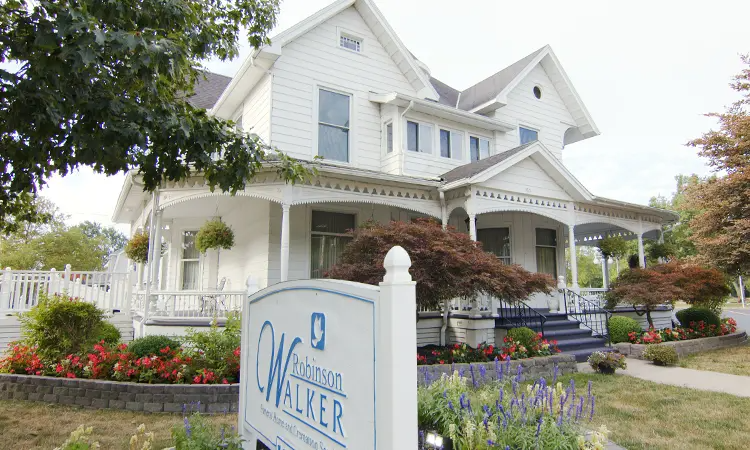 White Victorian house with a sign that reads "Johnson Walker".